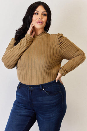a woman posing for a picture wearing a brown sweater
