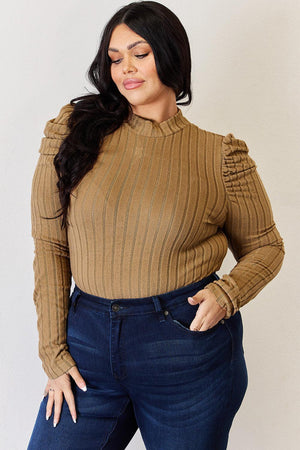 a woman wearing a brown sweater and jeans