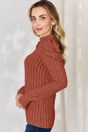 a woman wearing a brown turtle neck sweater