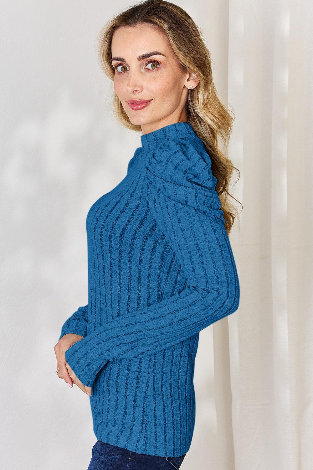 a woman in a blue sweater posing for a picture