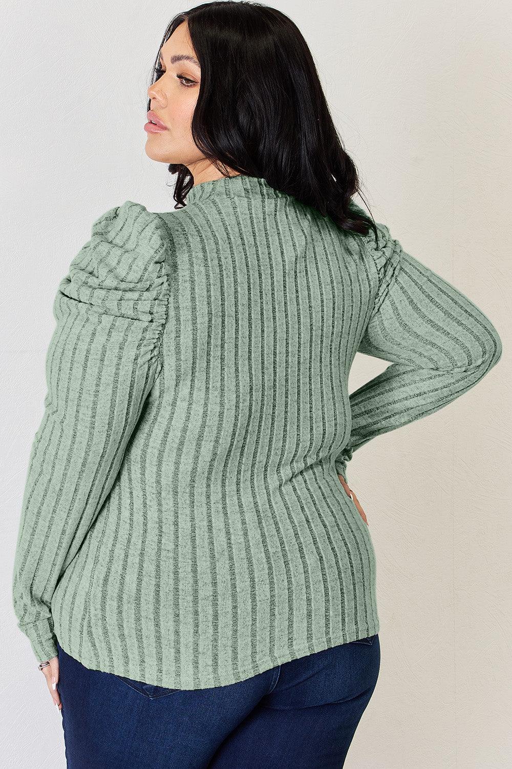 a woman wearing a green sweater and jeans