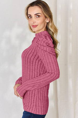 a woman in a pink sweater poses for a picture