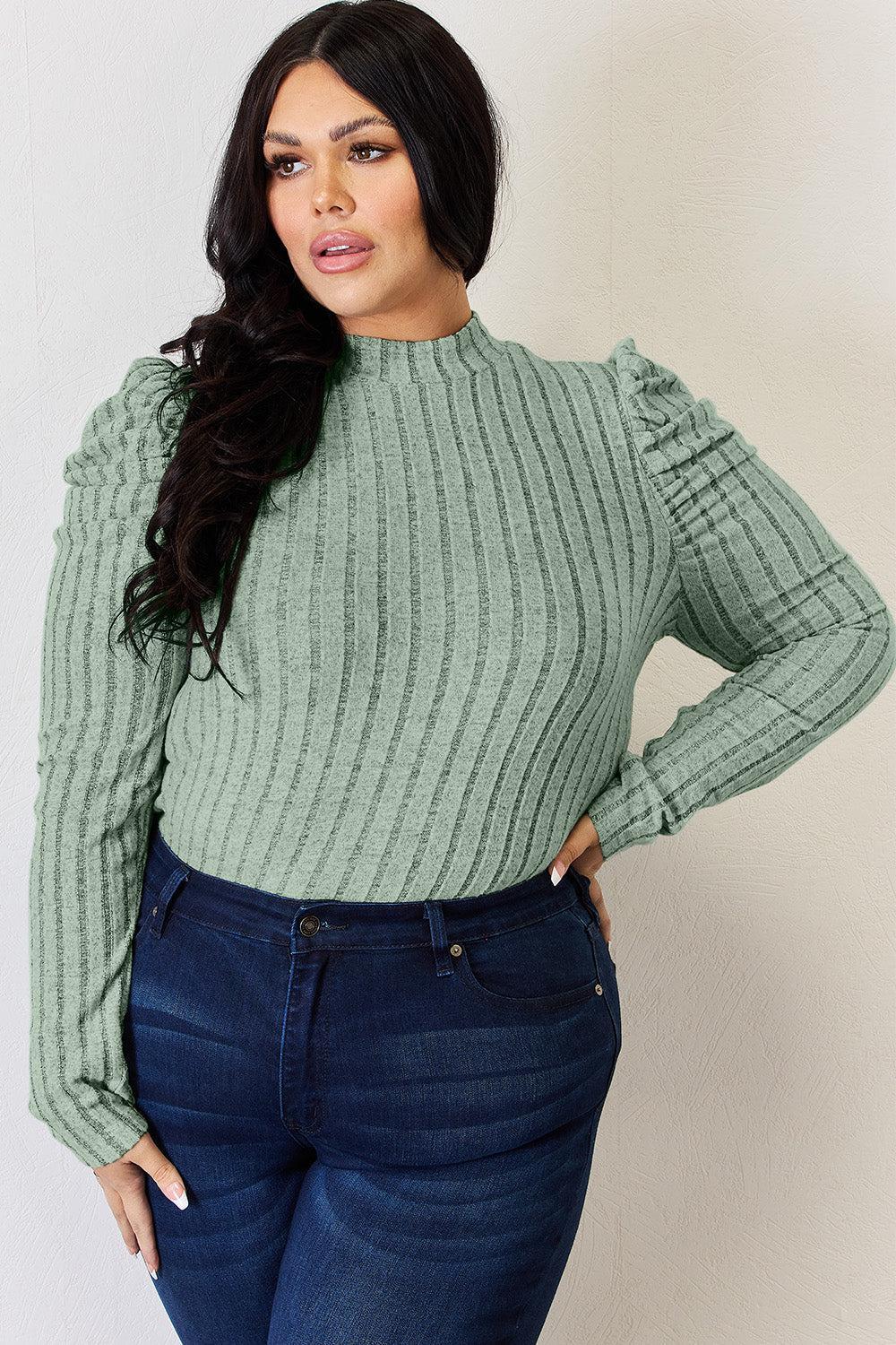 a woman in a green sweater poses for a picture