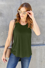 a woman wearing a green tank top and jeans