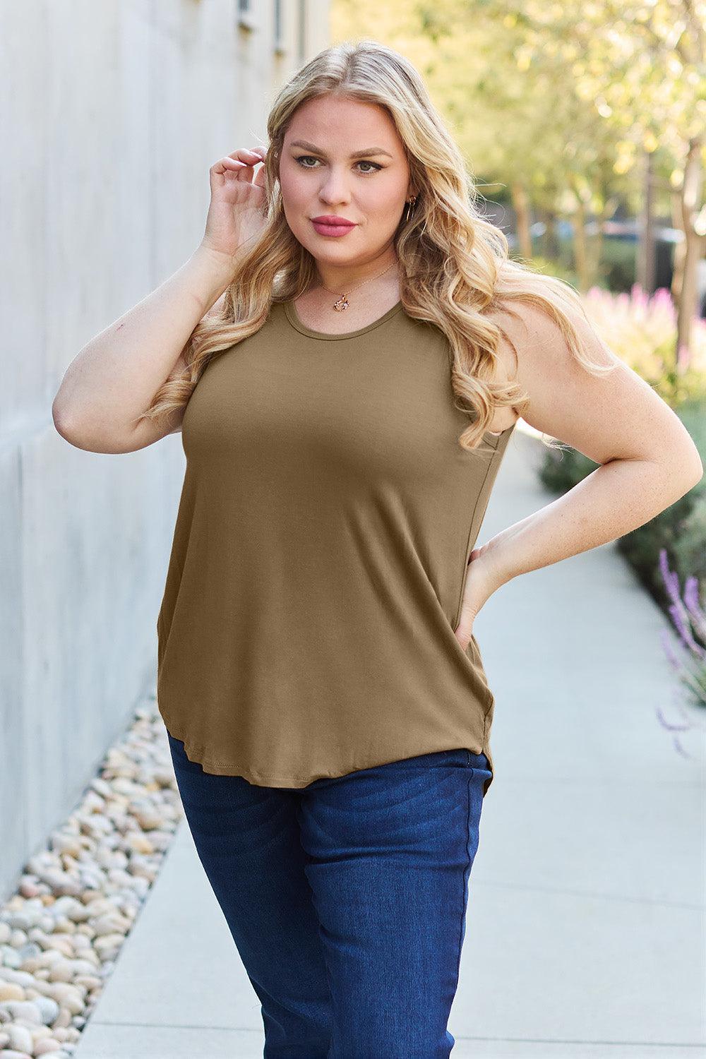 a woman posing for a picture wearing a tan top