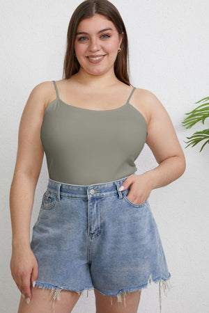 a woman wearing a grey tank top and denim shorts