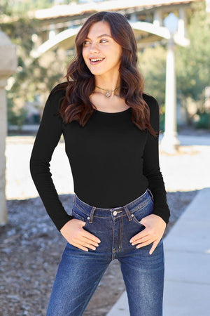 a woman in a black shirt and jeans posing for a picture