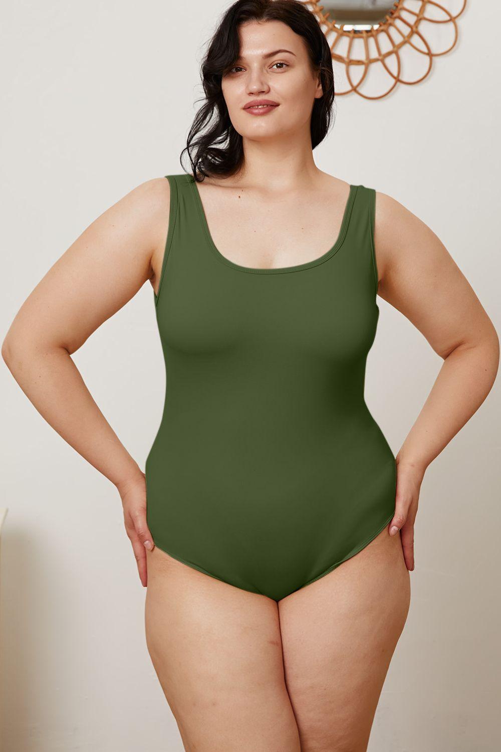 a woman in a green swimsuit posing for a picture