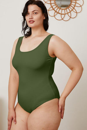 a woman in a green bodysuit posing for the camera