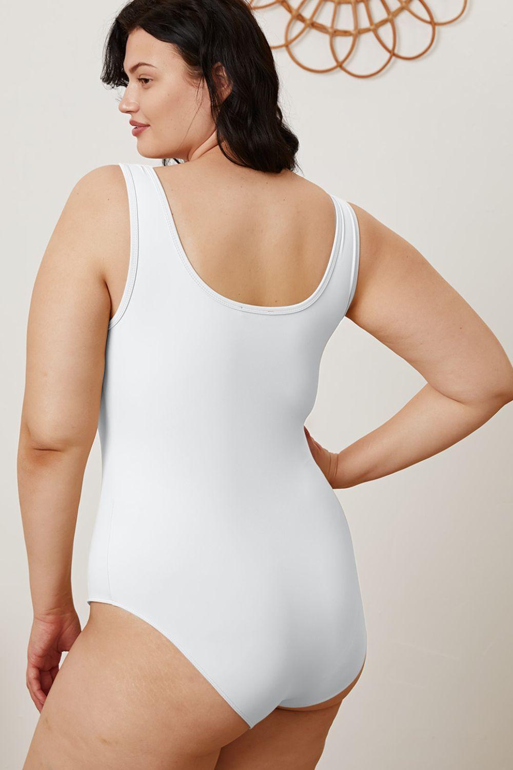 a woman in a white bodysuit with her hands on her hips