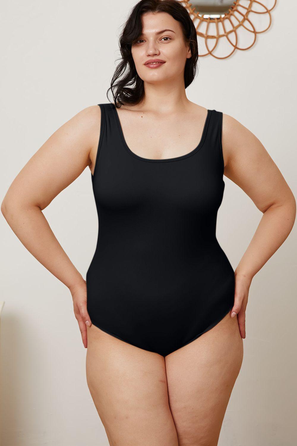 a woman in a black swimsuit posing for a picture