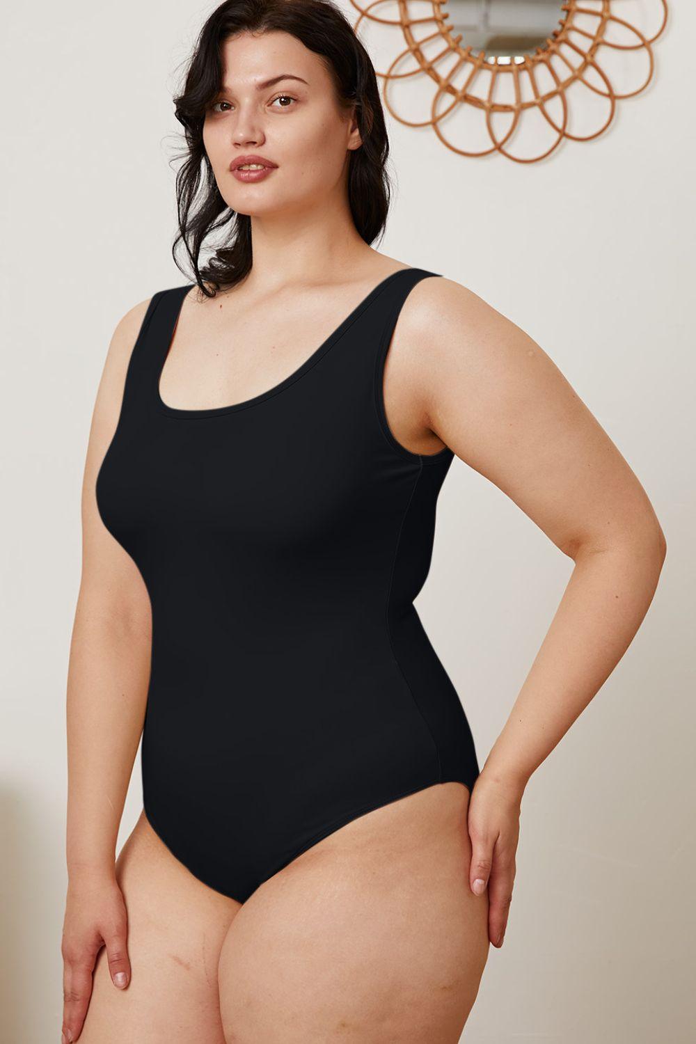 a woman in a black bodysuit posing for the camera