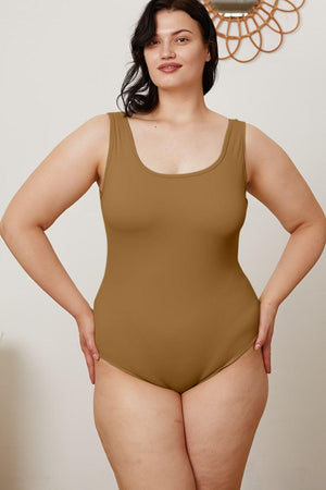a woman in a tan bodysuit posing for a picture