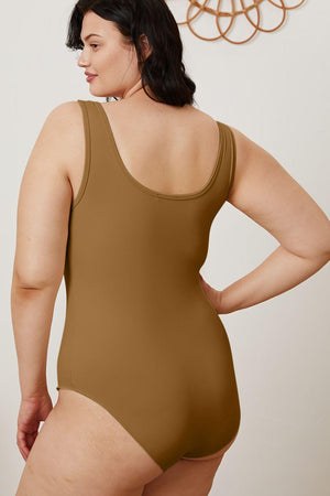 a woman in a bodysuit with her hands on her hips