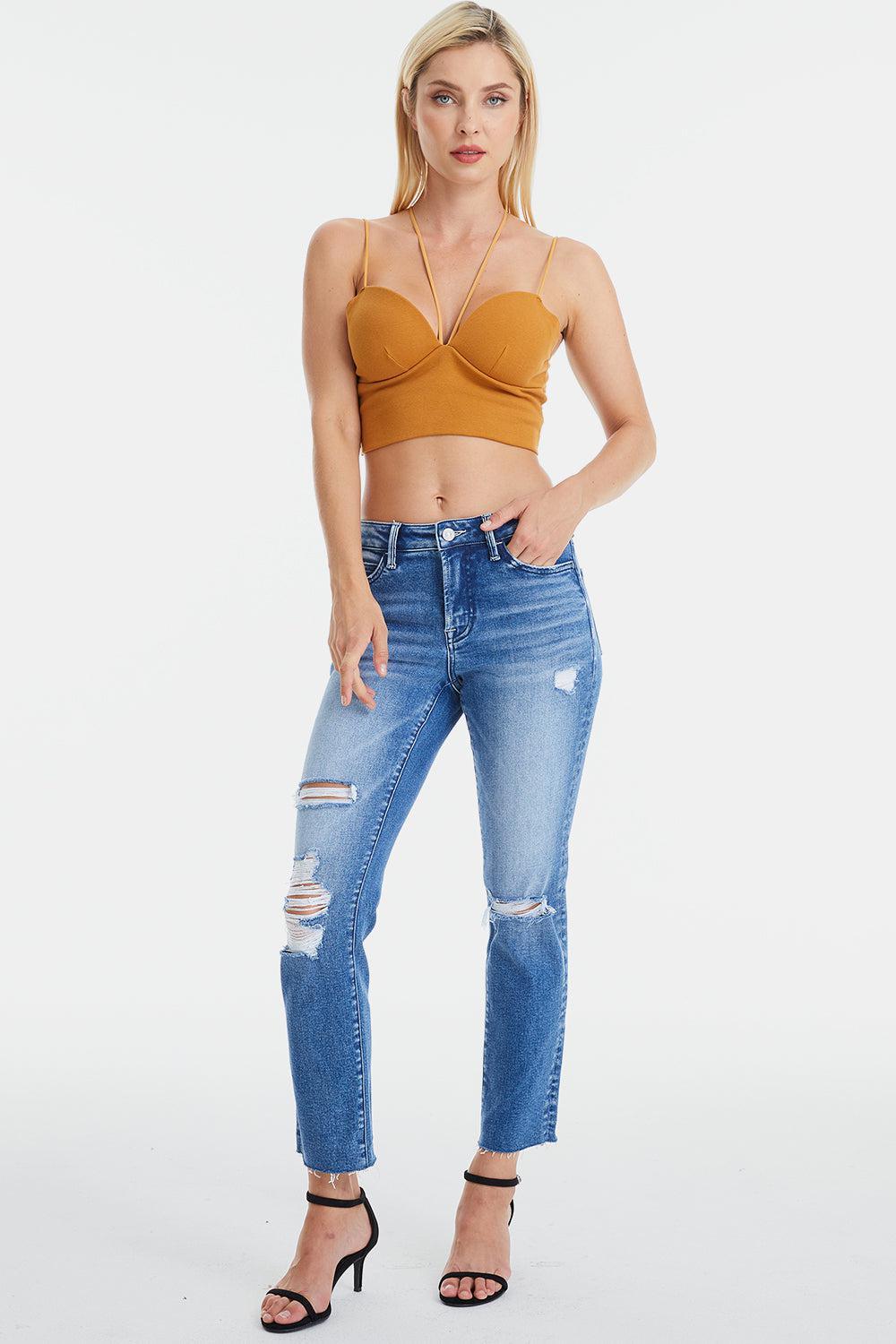a woman wearing a crop top and ripped jeans