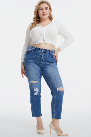 a woman in a white top and ripped jeans