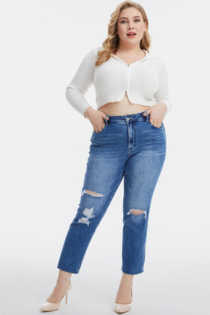 a woman in a white top and ripped jeans