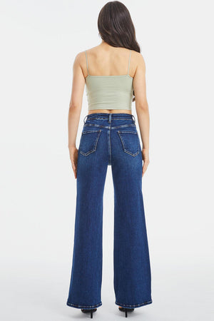 a woman wearing a crop top and wide jeans