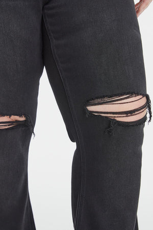 a woman wearing black ripped jeans with holes