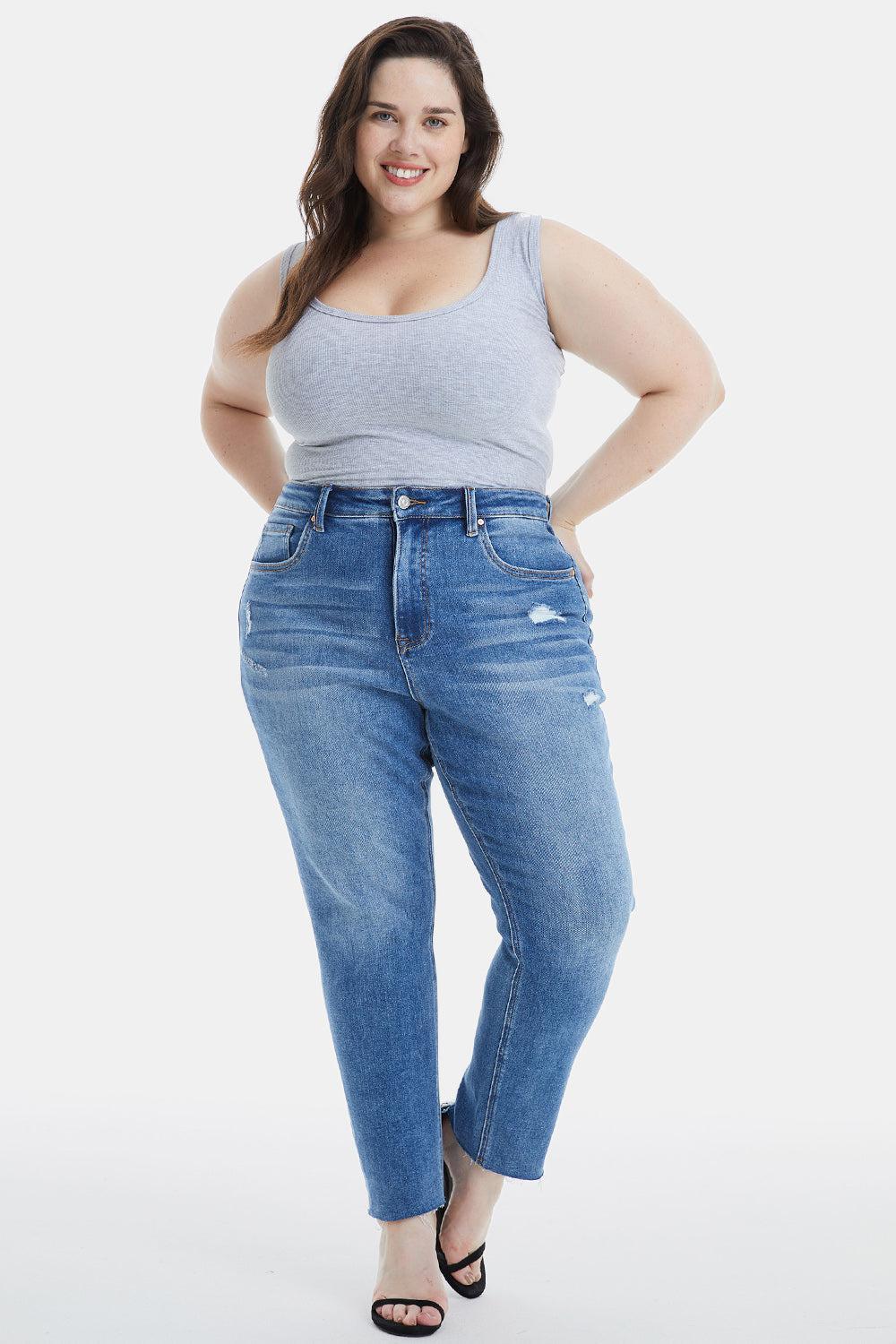 a woman in a tank top and jeans posing for a picture