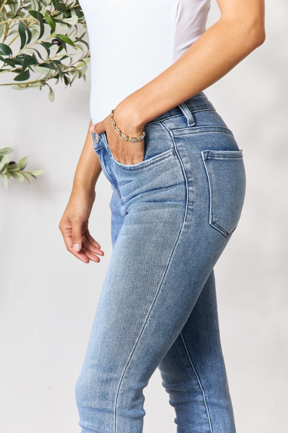 a woman in a white tank top and jeans