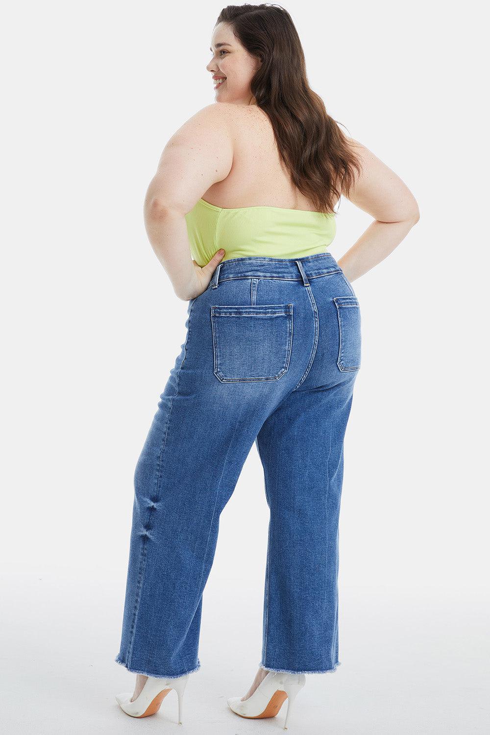 a woman wearing high rise jeans and a yellow tank top