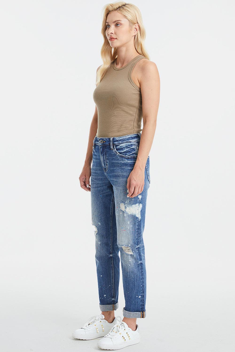 a woman in a tank top and ripped jeans