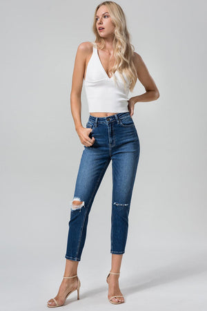 a woman in a white tank top and jeans