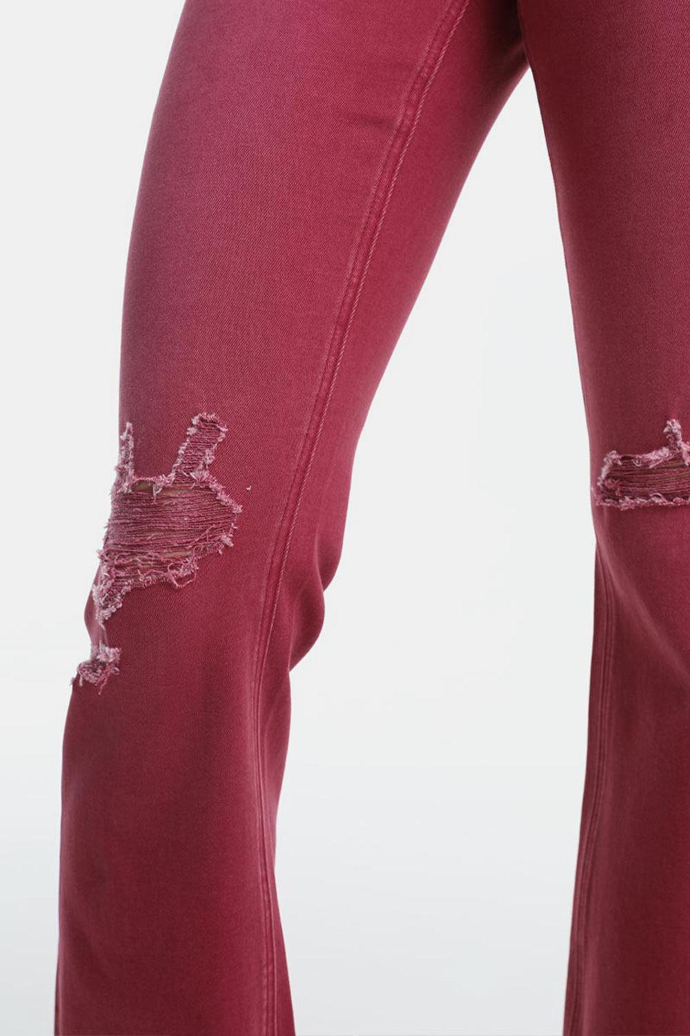 a pair of red jeans with holes on them