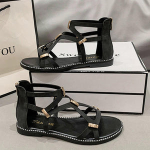 a pair of black sandals sitting on top of a white box