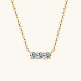 a gold necklace with three blue stones on it