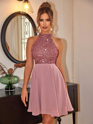 a woman in a short pink dress standing in front of a mirror