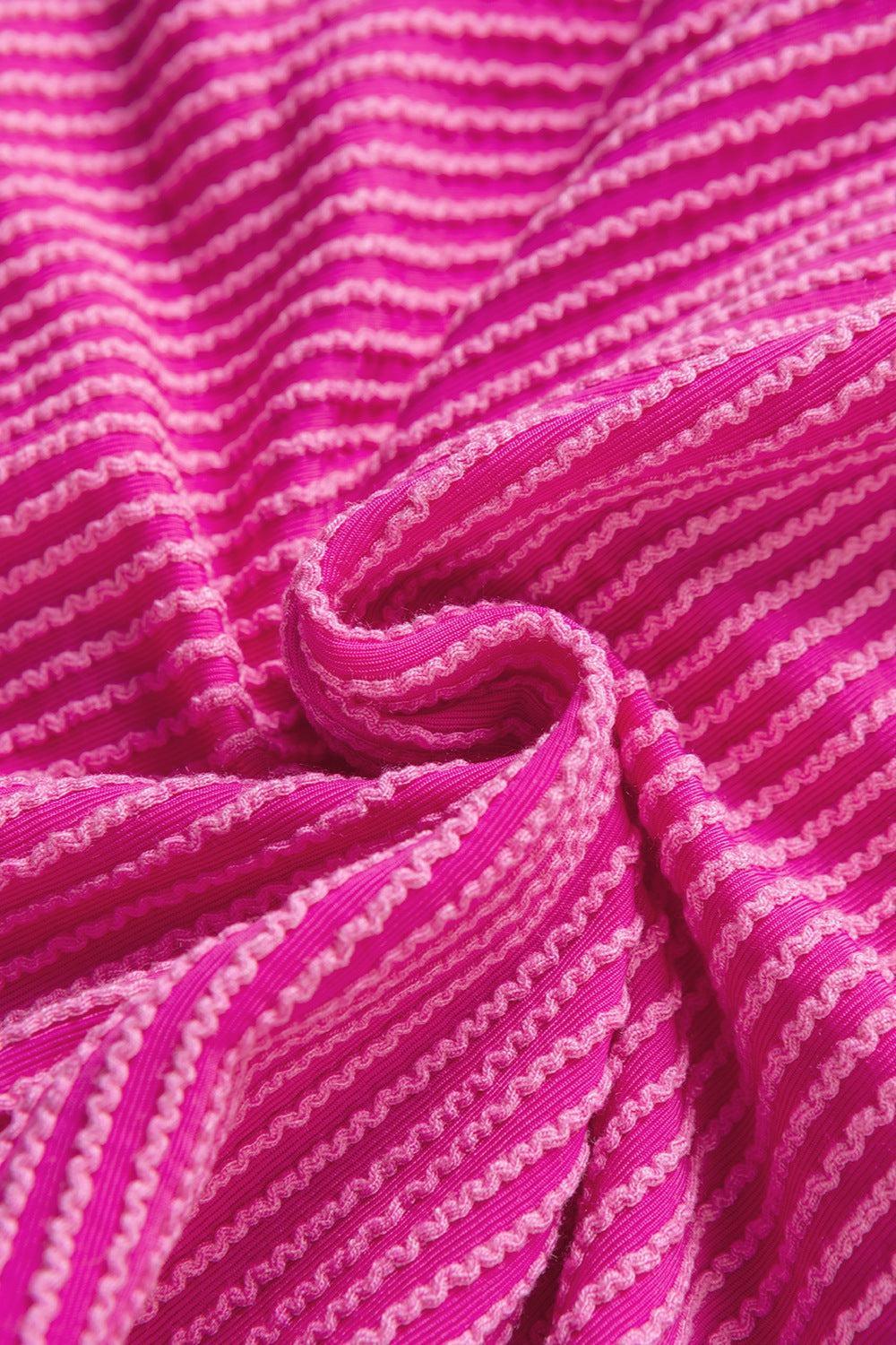 a close up of a pink and white knitted blanket