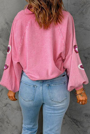 a woman wearing a pink top and jeans