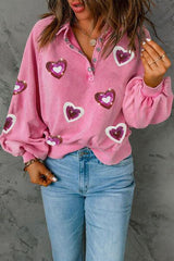 a woman wearing a pink shirt with hearts on it