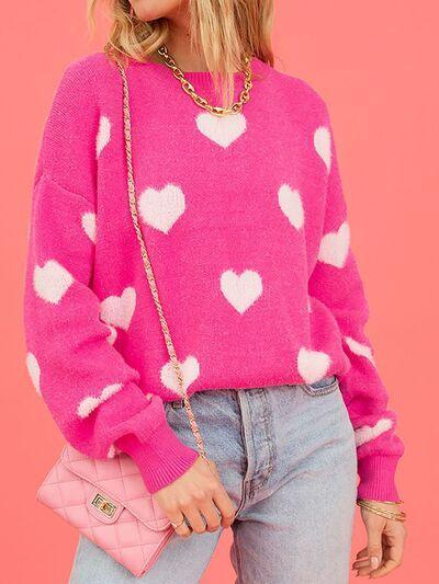 a woman wearing a pink sweater with hearts on it