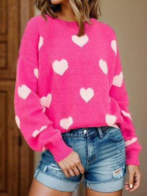 a woman wearing a pink sweater with hearts on it