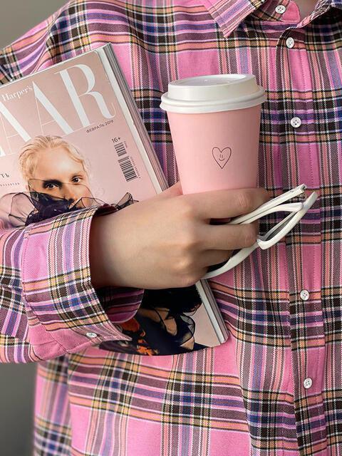 a person holding a book and a cup of coffee