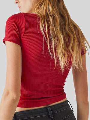 a woman wearing a red top and black jeans