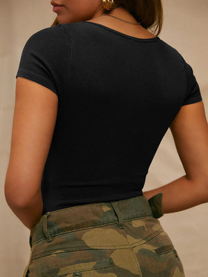 a woman in a black shirt and camo skirt