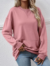 a woman wearing a pink sweatshirt and jeans