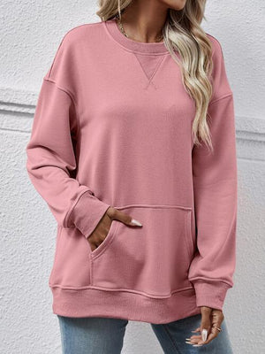 a woman wearing a pink sweatshirt and jeans