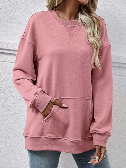 a woman wearing a pink sweatshirt and jeans