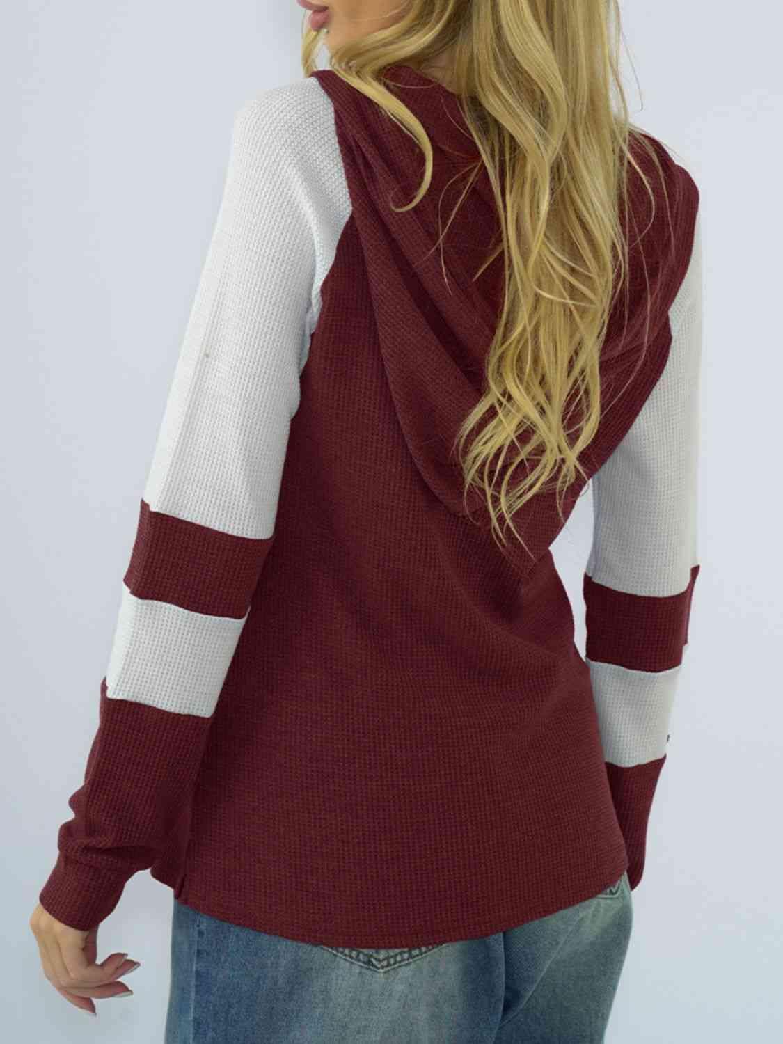 a woman wearing a maroon and white hoodie