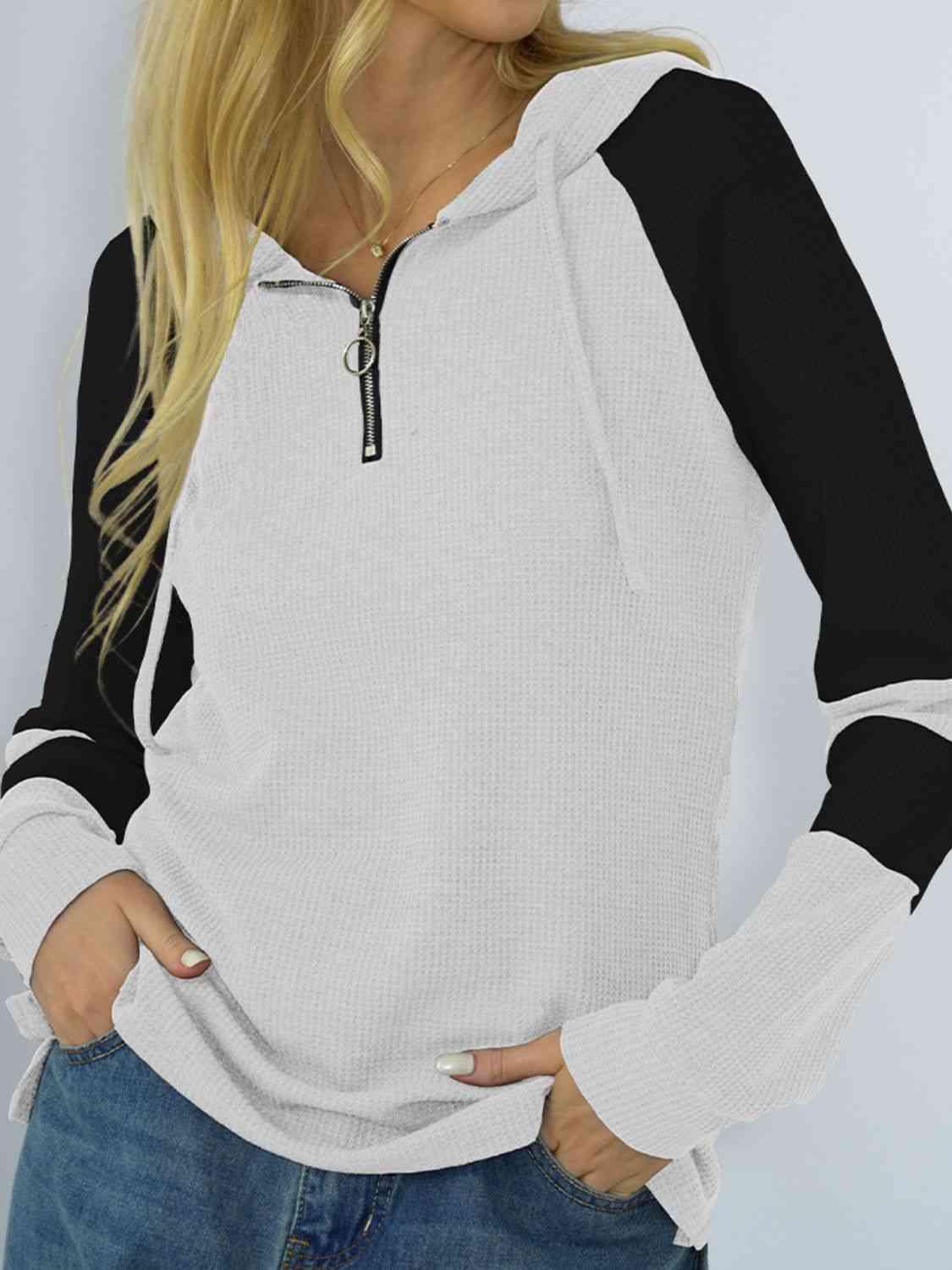 a woman wearing a white and black hoodie