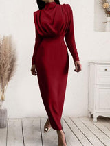 a woman in a red dress walking down a wooden floor