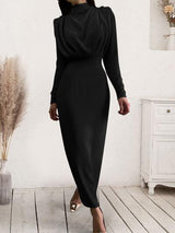 a woman in a black dress standing on a wooden floor