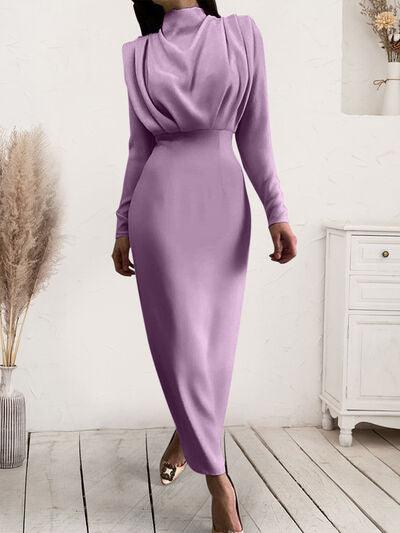 a woman in a purple dress walking down a wooden floor