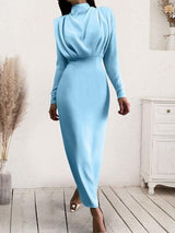 a woman in a blue dress walking down a wooden floor