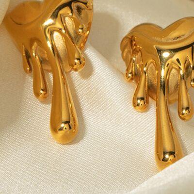 a pair of gold toned earrings on a white cloth